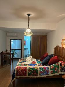 a bedroom with a bed with a colorful blanket at Pousada Neptun in Conde