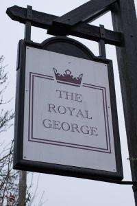 a sign for a royal store on a wooden pole at Royal George in Great Easton