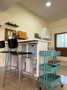 a kitchen with two bar stools and a counter top at PVS Kinabalu in Tuaran
