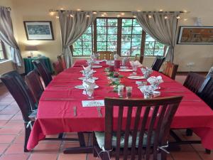 une longue table avec un chiffon de table rouge dans l'établissement Marula Gardens, à Mtubatuba