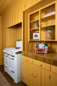 cocina con armarios amarillos y estufa blanca en Casa Cody, en Palm Springs