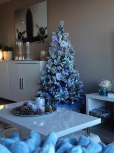 ニーウポールトにあるZonnestraal 0302のリビングルーム(テーブル付)の青いクリスマスツリー