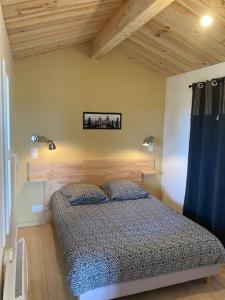 - une chambre avec un lit dans une pièce dotée de plafonds en bois dans l'établissement l'Observatoire de l'Aérogrange, à Biscarrosse
