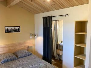 Un dormitorio con una cama y estanterías. en l'Observatoire de l'Aérogrange en Biscarrosse