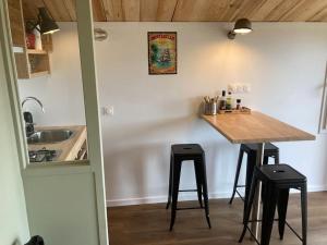 a kitchen with a counter and a table and stools at l'Observatoire de l'Aérogrange in Biscarrosse +26 photos