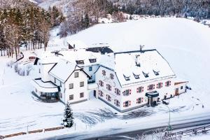 ルンツ・アム・ゼーにあるLandhotel Zellerhofの雪に覆われた家屋の空見