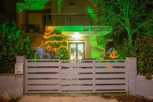 une clôture blanche devant un bâtiment aux lumières de Noël dans l'établissement Chris Cozy Apartment, à Ioannina