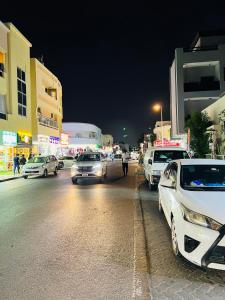 un grupo de autos estacionados en una calle de la ciudad por la noche en Comfort Tourist Place for male, en Dubái