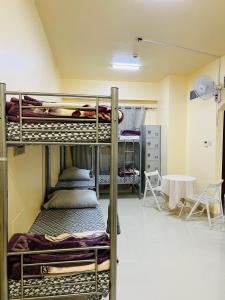 two bunk beds in a room with a table at Comfort Tourist Place for male in Dubai