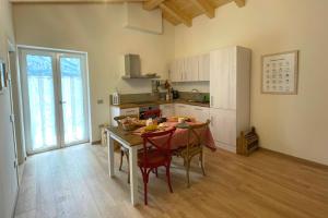 a kitchen with a table and chairs in a room at Serendipity House Valle dei Laghi in Sarche di Calavino