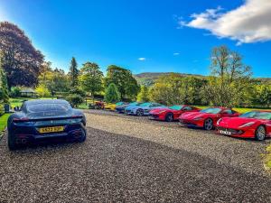 a row of parked cars parked in a parking lot at The Old Manse of Blair, Boutique Hotel & Restaurant in Blair Atholl