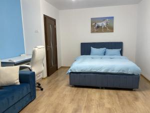 een slaapkamer met een bed, een stoel en een bank bij Turquoise Studio Nerva Traian in Boekarest