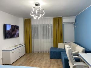 salon z niebieską kanapą i telewizorem w obiekcie Turquoise Studio Nerva Traian w Bukareszcie
