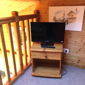 una TV su un supporto in legno in una stanza di Appartement lumineux avec balcon à Arêches Beaufort a Beaufort