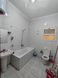 a bathroom with a tub and a toilet and a sink at Hurghada El Kawser Compound lotus in Hurghada