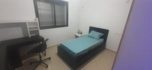 een kleine slaapkamer met een bed en een bureau bij Settat Zen Ferme in Maachat