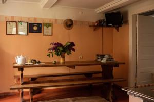 Una habitación con una mesa con un jarrón de flores. en Coastal Home Muini Ūši, en Kolka