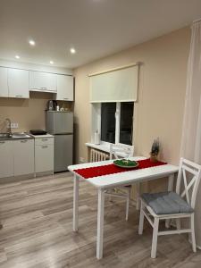eine Küche mit einem weißen Tisch und Stühlen in einem Zimmer in der Unterkunft ESSE Apartament in Gulbene