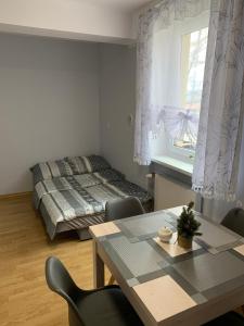 a bedroom with a bed and a table with chairs at Pokoje gościnne Pod Lwami in Kudowa-Zdrój