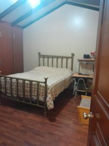 1 dormitorio con 1 cama y suelo de madera en LA CASA DE SYLVANA, en Quito