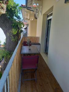 a wooden table and chairs on a balcony with a tree at VILLA DEGANNE T2 Plein sud in Arcachon +4 photos