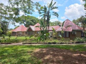 a house with red roofs in a yard at Marula Gardens in Mtubatuba