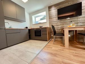 a kitchen with a table and a television on a wall at Appartement FELIX in Mariapfarr