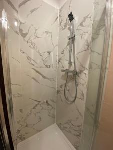 a bathroom with a shower with marble walls at 1 bedroom Luxury Apartments by London City in London