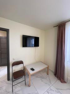 um quarto com uma mesa e uma cadeira e uma televisão na parede em LUXflats Rivne em Rivne
