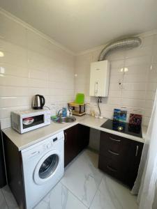 a kitchen with a washing machine and a microwave at LUXflats Rivne in Rivne