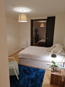 a bedroom with a large bed and a blue rug at Entire Flat - Modern Flat near Canary Wharf in London