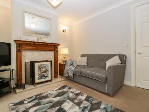 a living room with a couch and a fireplace at 2 Bathsheba Terrace in Dorchester