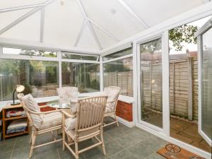 a conservatory with windows and a table and chairs at 2 Bathsheba Terrace in Dorchester