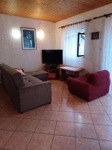 ein Wohnzimmer mit 2 Sofas und einem TV in der Unterkunft Guesthouse Murter 125 in Murter