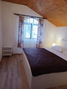 a bedroom with a large bed with a window at Guesthouse Murter 125 in Murter
