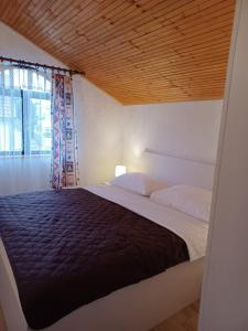 um quarto com uma cama grande e um tecto em madeira em Guesthouse Murter 125 em Murter
