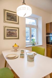 a kitchen with a white table and green chairs at Vila Krista in Maribor