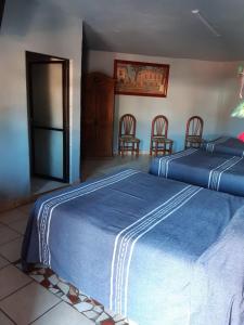 een slaapkamer met 2 bedden en een tafel en stoelen bij posada San Alejandro in Pátzcuaro
