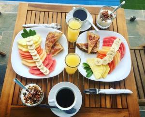 uma mesa com dois pratos de comida e bebidas para o pequeno-almoço em Heartland hotel em Kigali