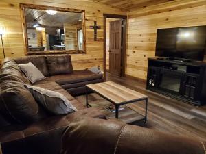 een woonkamer met een bank en een flatscreen-tv bij Luxury Cabin w/ Game Room & Hot Tub at Cave Run Lake in Wellington