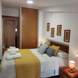 um quarto com uma cama grande com almofadas amarelas e azuis em las llaves del arca em Trujillo