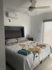 a bedroom with a large bed with a fan at Casa Nora in Sisal
