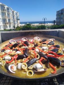 een pan gevuld met vis en groenten op een grill bij A pasos del mar Lugar ideal para descansar in El Tabo