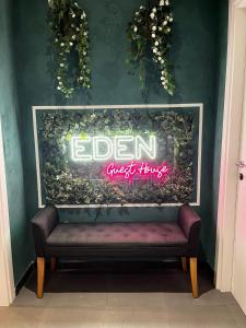 Eden guest house في روما: علامة على جدار مع مقاعد في غرفة