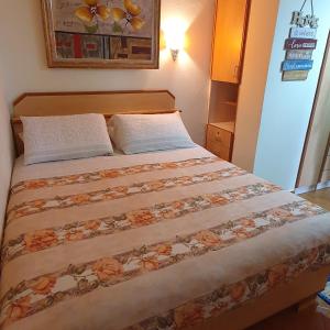 1 cama en una habitación pequeña con 2 almohadas en Apartment Sea View, en Shëngjin