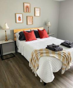 a bedroom with a large white bed with red pillows at The Delores - 2 Bedroom Apt in Quilt Town, USA in Hamilton