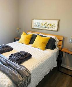 Hamilton的住宿－The Delores - 2 Bedroom Apt in Quilt Town, USA，一间卧室配有一张带黄色和黑色枕头的床