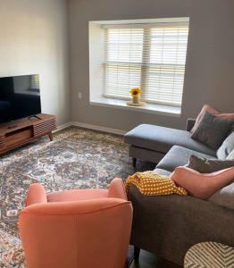 a living room with a couch and a tv at The Delores - 2 Bedroom Apt in Quilt Town, USA in Hamilton