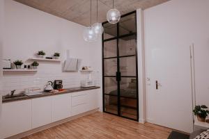 una cucina con armadi bianchi e una porta in vetro di Old Town WAWEL Premium Apartment - 60m2 a Cracovia