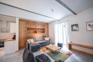 a living room with a couch and a table at FarmHouse Eckartsberg im Zittauer Gebirge - Gemütliche und moderne Ferienwohnungen mit Terrasse in Eckartsberg